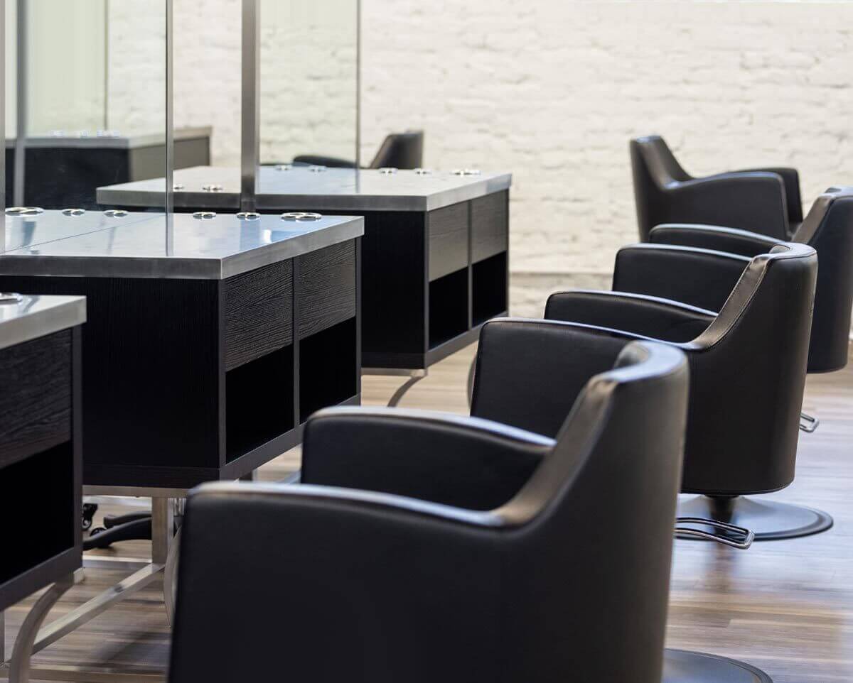 Black Venturi Salon Styling Chairs paired with the black wood and stainless finish Aurora Styling Stations